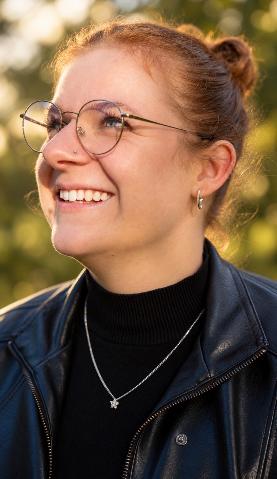 Lächelnde Frau mit Brille im Sonnenlicht